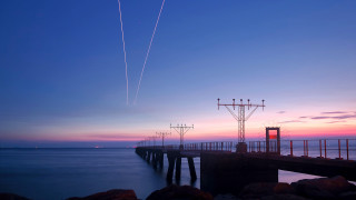 Pier plane sunset contrails water - a long pier free wallpaper