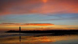 Lighthouse sunset ocean mountain beach - a small island in the distance free wallpaper