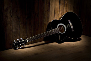 Guitar wooden table dark room - a wooden wall behind free wallpaper