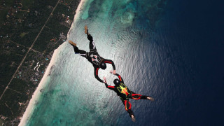 Flying people ocean land below - kitsch movement free wallpaper