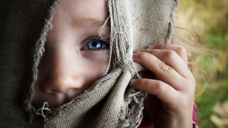 Child hiding bluish eyes blanket - a cloth free wallpaper