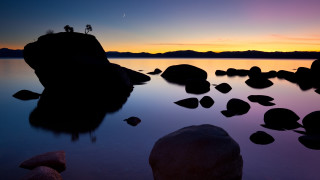 Lake rocks person silhouette sunset - a rock in the middle of it free wallpaper