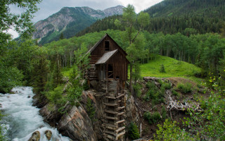 Cliffside wooden house river mountains - kodachrome free wallpaper