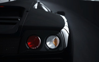 Black sports car lit up - the dark room of a building free wallpaper