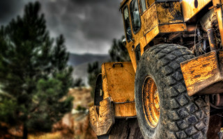 Yellow truck wooded area blurry - a dark sky in the background free wallpaper