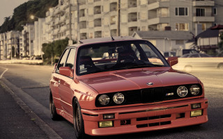 Red car tall building cityscape - the side of a road next free wallpaper