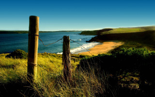 Wooden fence grassy hill ocean - a wooden fence free wallpaper