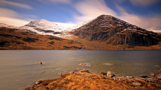 Mountain lake snowy background blue - a lake in the foreground and a snow free wallpaper