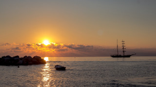 Boat ocean sunset rock mountain - a large rock free wallpaper