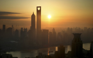 City skyline tower sunset bridge - a bright sun in the distance free wallpaper