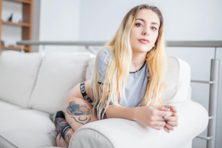 Woman couch tattoo blonde posing - her arm and chest free wallpaper