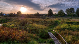 Wooden bridge grassy field sunset - a house in the distance free wallpaper