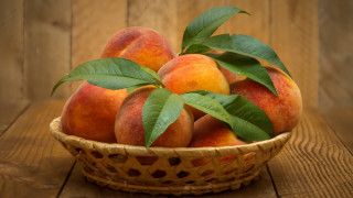 Basket peaches leaves wooden table 2 - a wooden wall free wallpaper