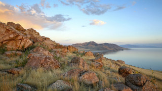 Rocky hillside lake clouds grass - a lake in the distance free wallpaper
