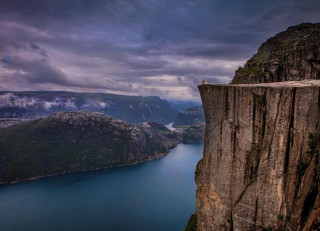 Cliff overlooking mountains water sky - a cloudy sky above them free wallpaper