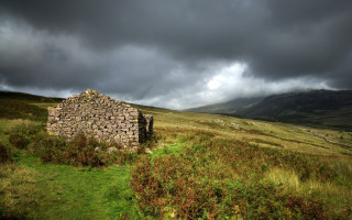 Stone building grassy field cloudy - a stone building free wallpaper