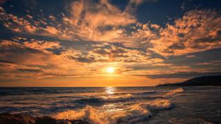 Sunset ocean wave rock person 2 - a rock in the foreground free wallpaper