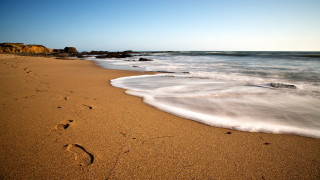 Beach waves footprints rock outcropping 2 - free beach wallpaper