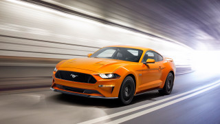 Bright orange mustang driving highspeed - a street free wallpaper