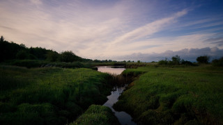 River lush field cloudy sky - a lush green field under a cloudy sky free wallpaper