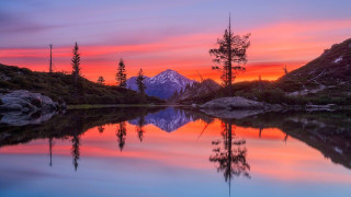 Mountain lake reflection sunset city - a red sky in the background free wallpaper
