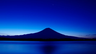 Mountain night blue sky ocean - a boat in the foreground free wallpaper for desktop