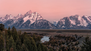Mountain range river trees sunset - a pink sky in the background free wallpaper