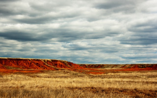 Grassy hill cloudy sky ocean - a grassy area in the foreground free wallpaper