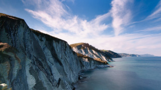 Cliff water blue sky clouds - a cliff face free wallpaper