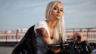 Tattooed woman motorcycle serious gothic - her face and shoulder free wallpaper