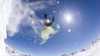 Snowboarder midair sunny mountains snowflakes - a snowboarder free wallpaper