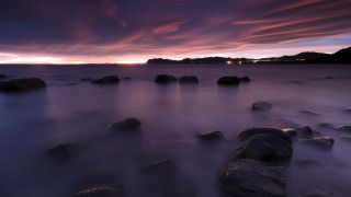 Sunset rocky beach city lights 2 - a long exposure of a sunset over a rocky beach free wallpaper