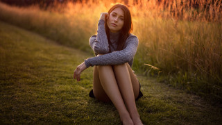Woman sitting field sunset portrait - the ground in a field of grass free wallpaper