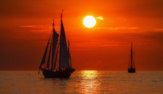 Sailboat ocean sunset mountain clouds - a sailboat free wallpaper