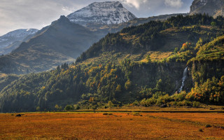 Mountain waterfall grassy field trees - a waterfall in the middle of it free wallpaper