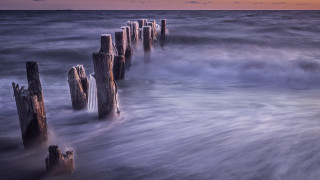 Long exposure pier sunset waves - a boat in the distance free wallpaper