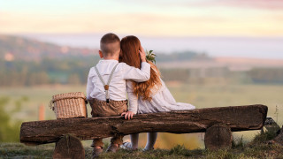 Couple sitting on log with - a basket of flowers free wallpaper