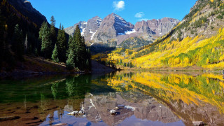 Mountain lake trees yellow leaves - the foreground and a mountain range in the background free wallpaper for desktop