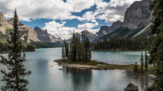 Lake mountains trees cloudy sky 17 - a small island in the middle of the water free wallpaper