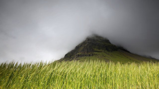 Tall green mountain grass field - a dark sky above free wallpaper