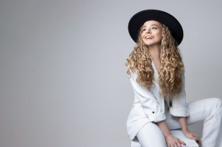 Woman blonde hat sitting blue - white pants free wallpaper