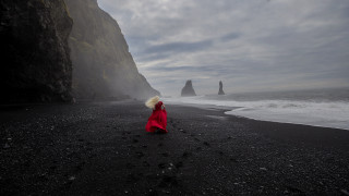 Beach red coat cliff ocean - a large rock formation in the background free wallpaper