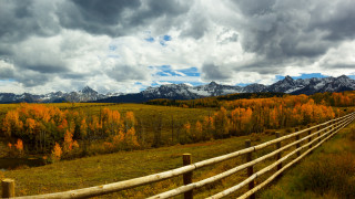 Wooden fence mountains clouds grassy - in a field free wallpaper