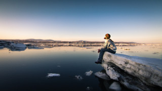 Person sitting overlooking ice floes - sense of awe free wallpaper