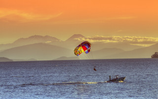 Parasailing ocean mountains sunset dawn - a parachute free wallpaper