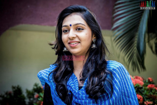 Woman blue shirt smiling outdoors - a plant behind her free wallpaper