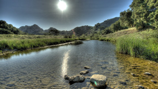 River rocks grass mountains sunlight - a bright sun in the sky free wallpaper