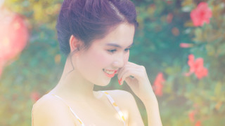 Woman smiling flower bush bokeh - a bun free wallpaper