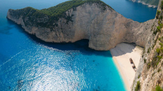 Beach rock formation boat cliff - a rock formation in the middle of it free wallpaper
