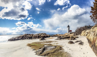 Lighthouse rocky shore cloudy sky - a beach below free wallpaper